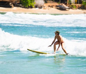 Surfer riding a wave at Hiriketiya beach near Hiriketiya beach hotels in Sri Lanka