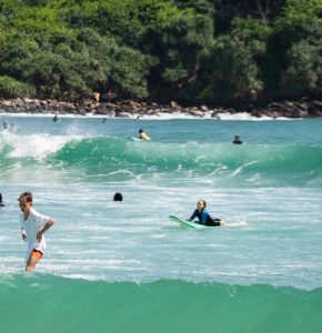 Surfing and swimming at Hiriketiya Bay Sri Lanka with turquoise waves and tropical beach