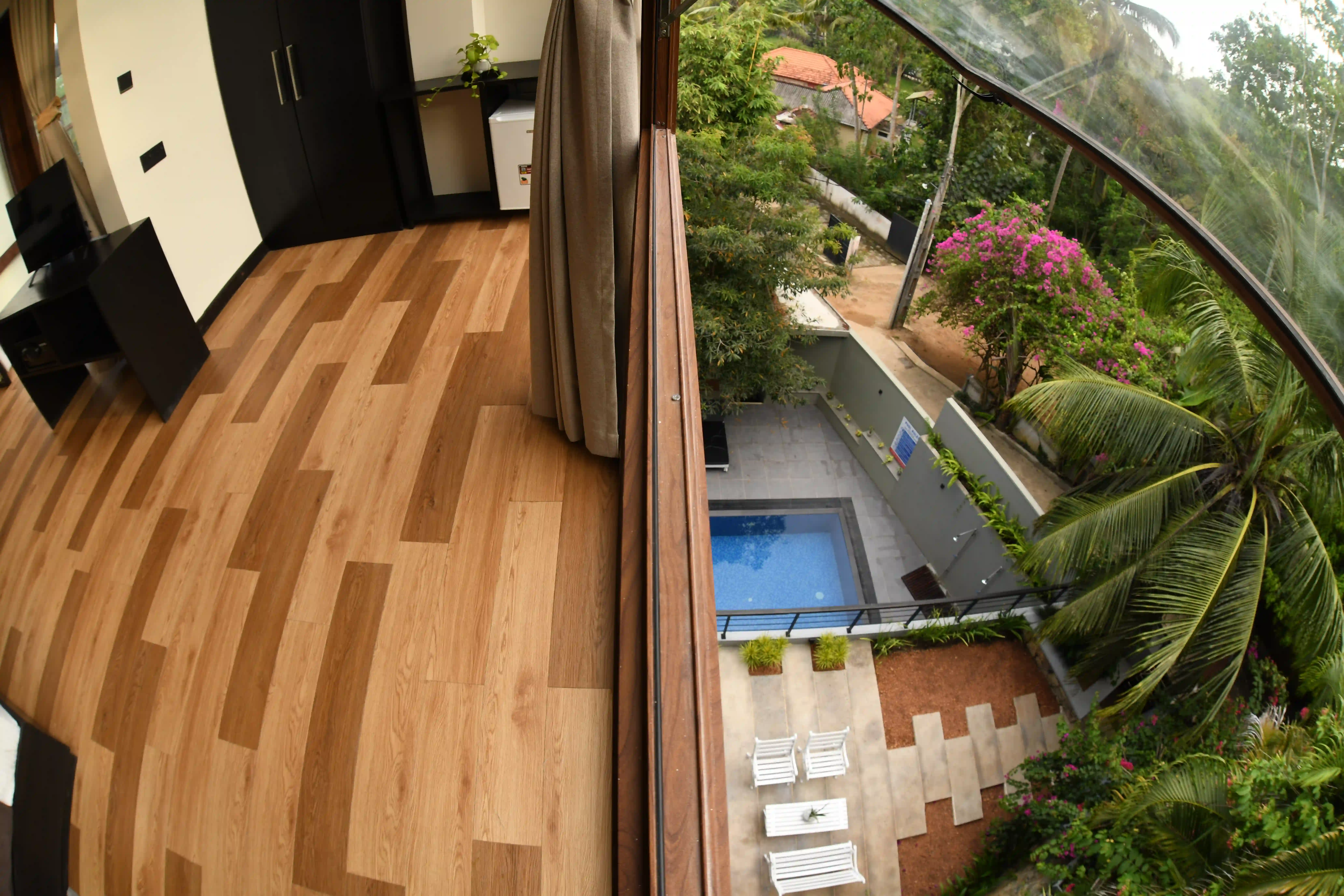 Balcony view overlooking pool and garden at Hiriketiya Beach Resort: comfortable Hiriketiya accommodation