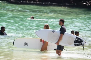 Couple carrying surfboards at Hiriketiya Bay Sri Lanka near Hiriketiya Beach Resort